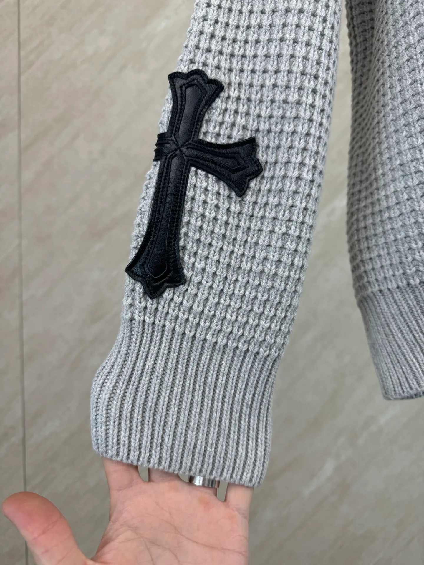 P570 Chrome Hearts cashmere waffle sweater size s m l The main body fabric is made of custom-woven and dyed cashmere and mulberry silk blended yarn. The whole dress takes nearly 200 minutes. The Chrome Hearts cross leather on both sides of the sleeves is genuine sheepskin. The hardware and cross sheepskin are all hand-sewn. The labor cost is extremely high. The back hardware accessories are molded and made to order. They are aged and oxidized.